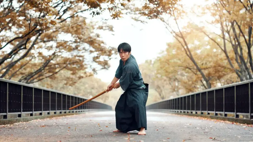 Martial arts, man and wood sword outdoor with fight, battle and samurai training on road. Park, urb